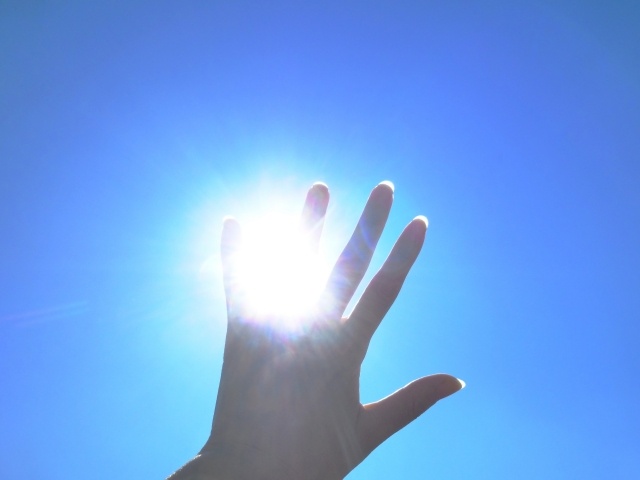 太陽に手をかざす
